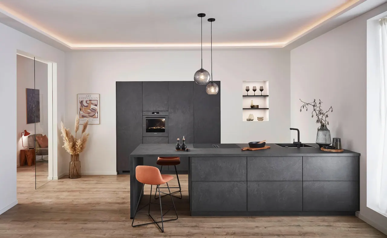 Dark stone-look kitchen island under warm cove lighting